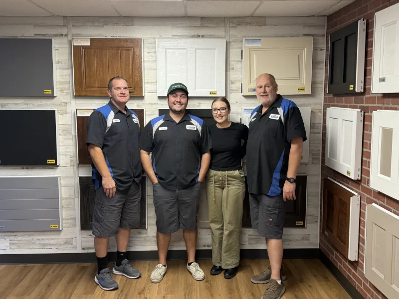 Archway Garage Doors team with garage door panel options and showroom display.