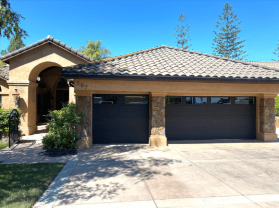 Saugus home exterior with new dark gray garage door and stone accents.