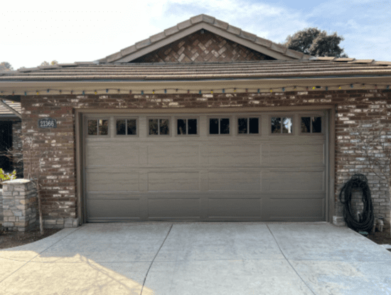 Garage door cable repair in Encino, California, with a modern garage door on a brick home.