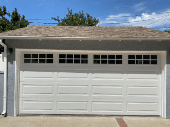 White garage door installation in Saugus, California, with window details and a residential setting.
